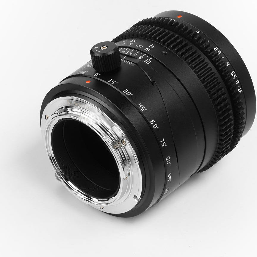 Black manual focus lens shown at three-quarter angle displaying focus ring, aperture markings, and metal mount against white background.