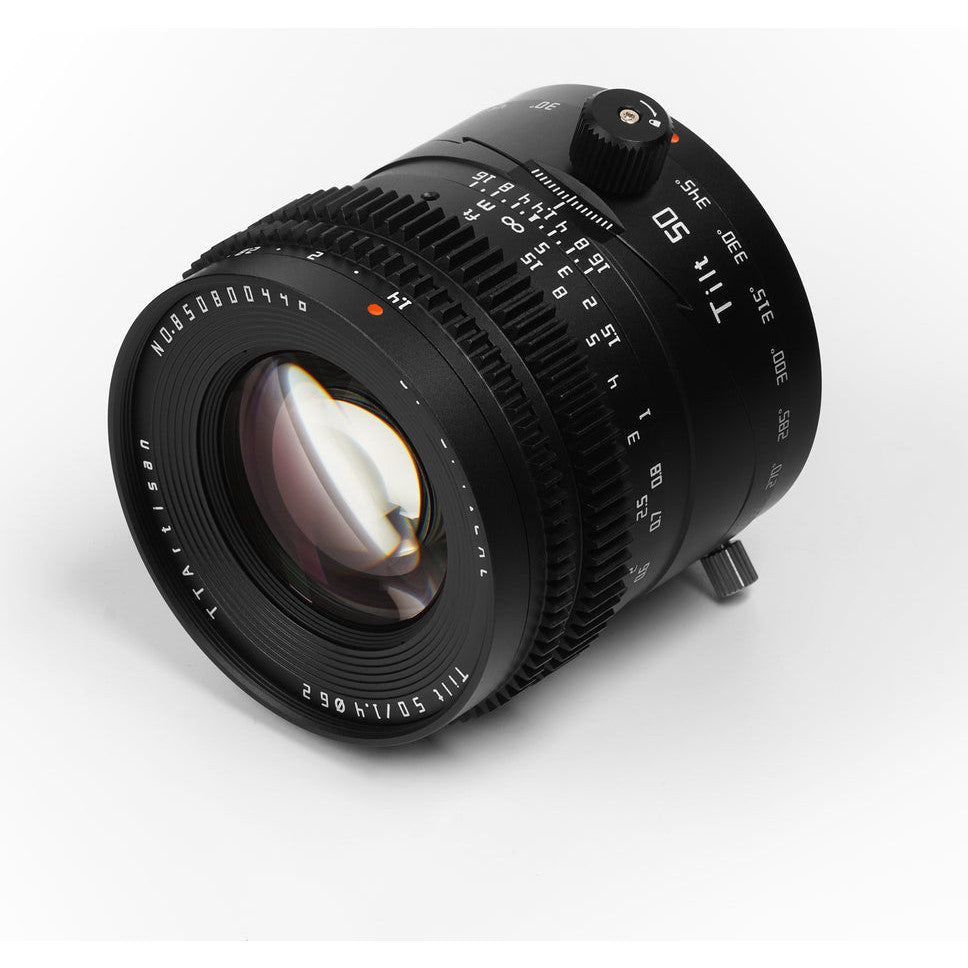 Black TTArtisan 50mm f/1.4 tilt lens shown at three-quarter angle against white background, displaying front glass element and control ring details.