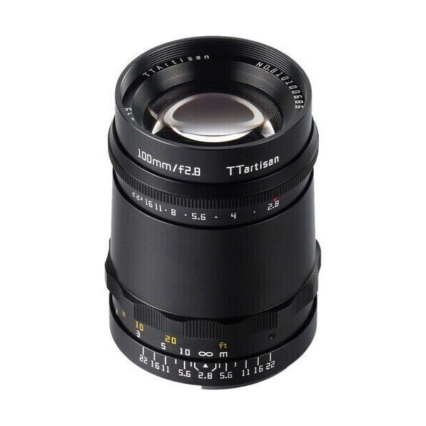 Black TTArtisan 100mm f/2.8 lens shown from front angle against white background, displaying glass element, focus ring, and aperture markings.