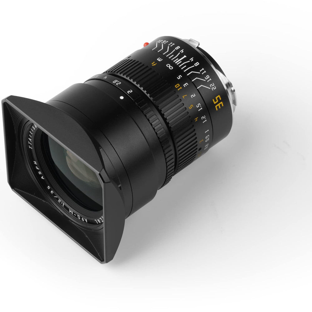 Black TTArtisan 35mm f/2 APO lens with square lens hood attached, shown at three-quarter angle against white background.