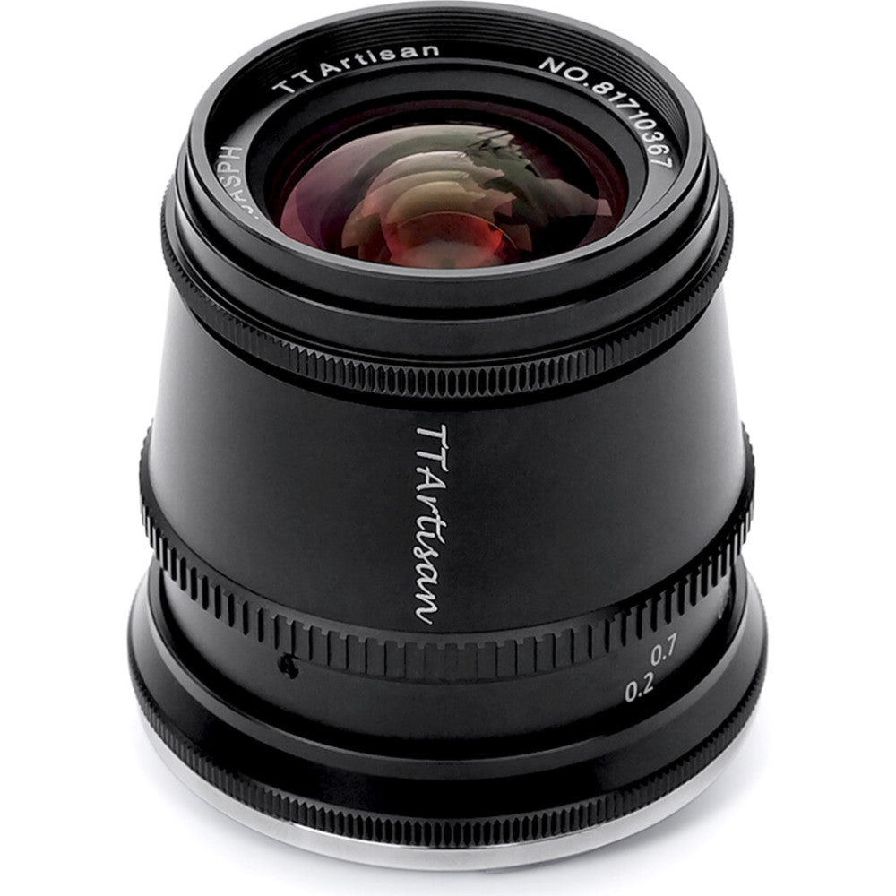 Black TTArtisan 17mm f/1.4 lens shown from front angle against white background, displaying glass elements and focus ring details.