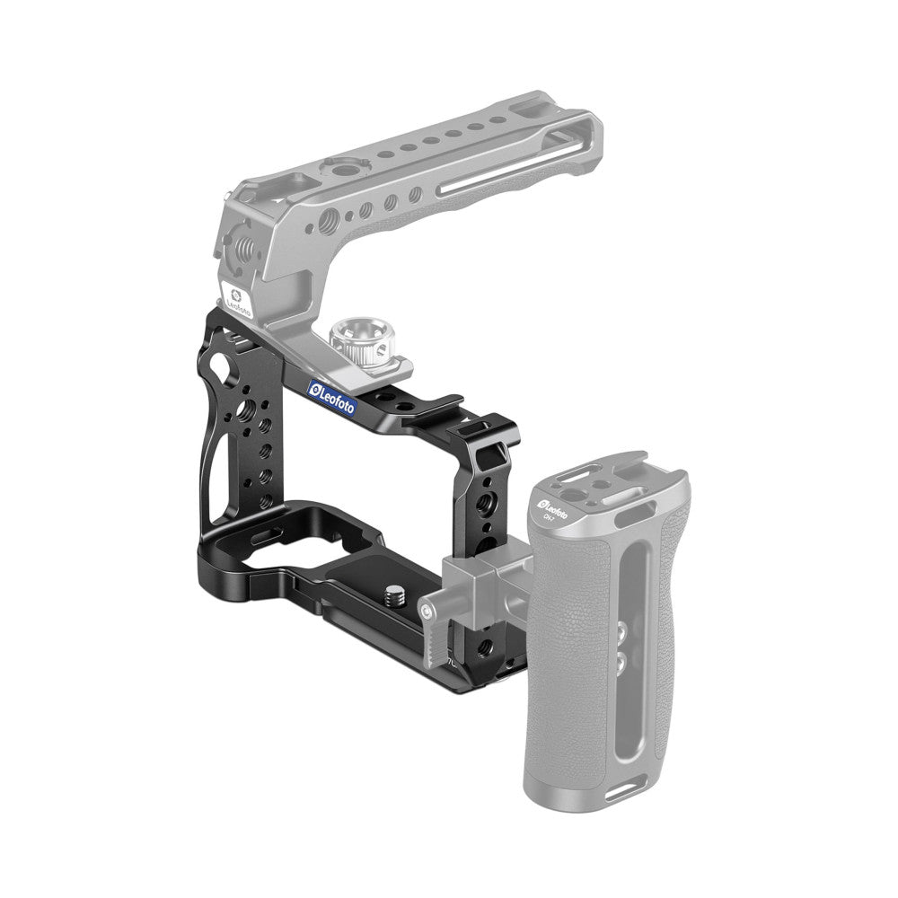 Black aluminum camera cage with top handle and shoe mount, shown with mounted accessories and camera body in isometric view.