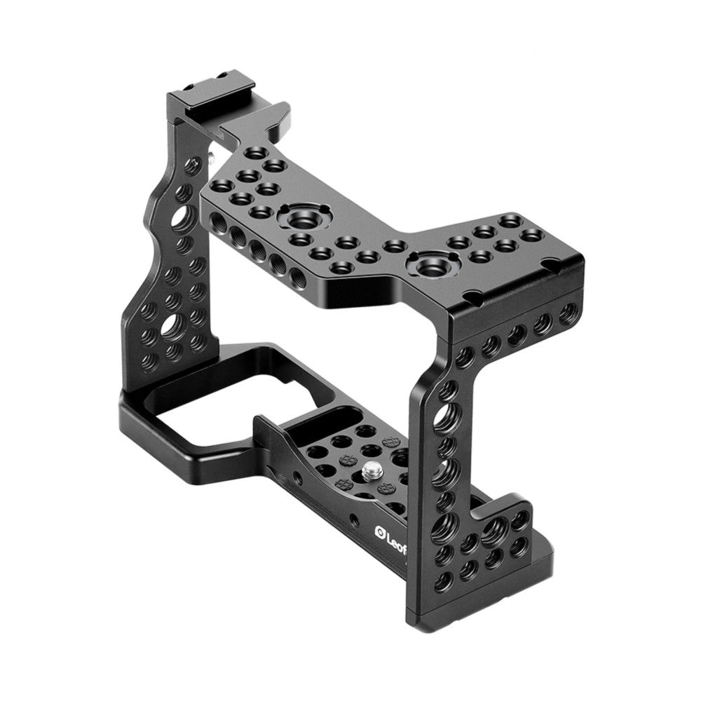 Black metal camera cage with multiple mounting holes shown at an angle, displaying the frame structure and top handle attachment point.