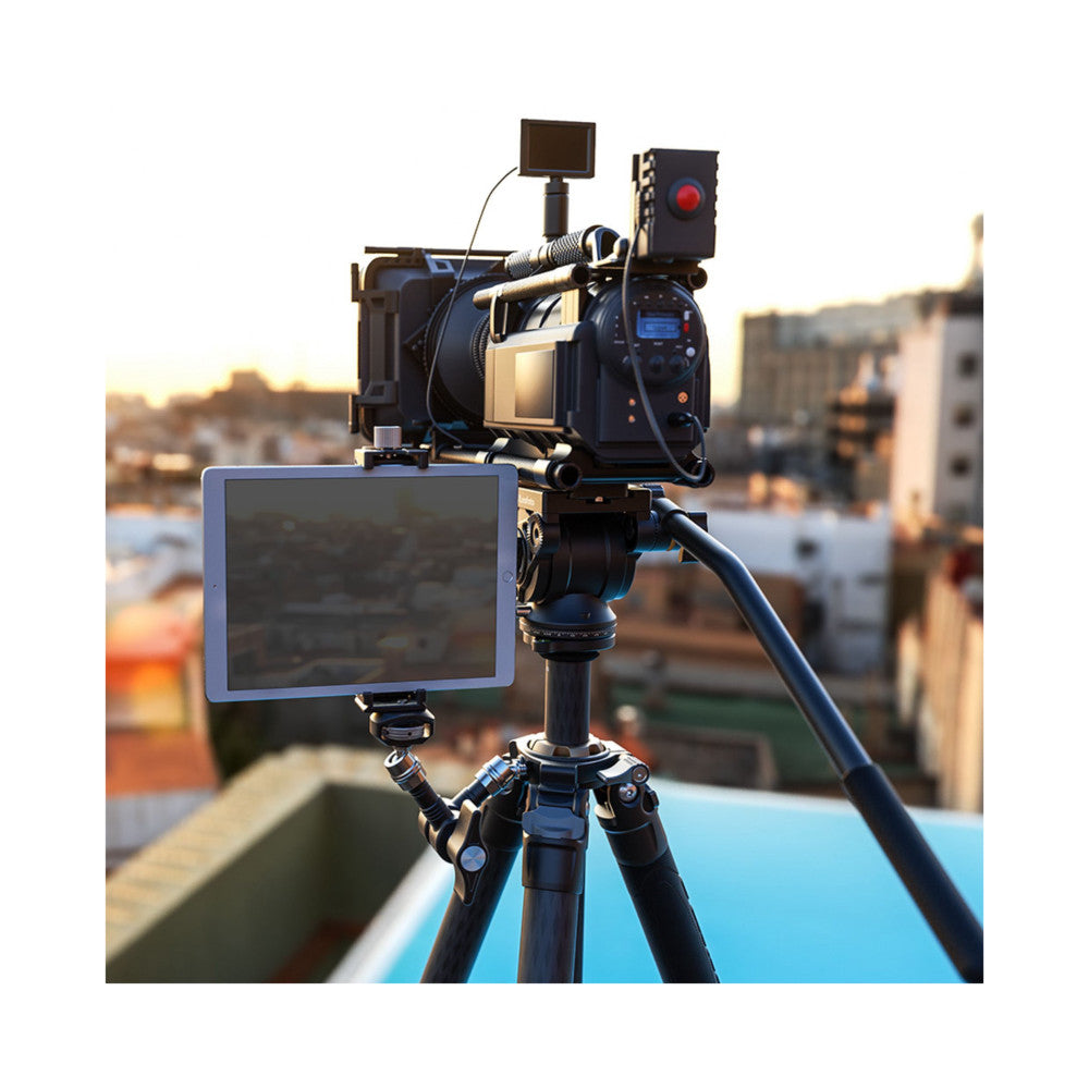 Professional camera rig mounted on tripod with magic arm articulating a monitor and microphone, filmed outdoors overlooking cityscape at sunset.