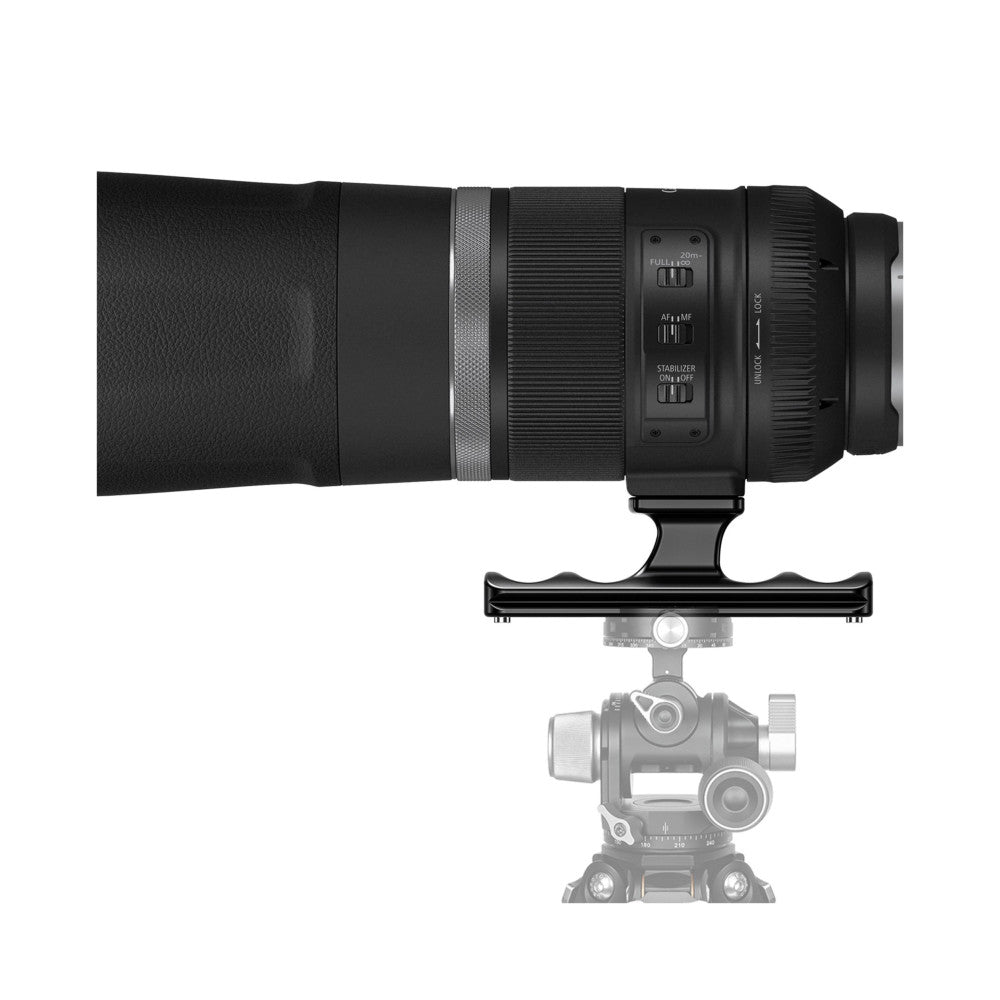 Side view of black telephoto lens mounted on gimbal head with Arca-Swiss foot attachment visible underneath.