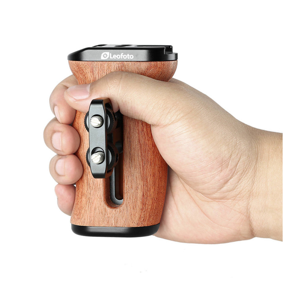 Hand holding Leofoto CH-3 rosewood side handle with black metal fittings, showing grip and lever mechanism in use.