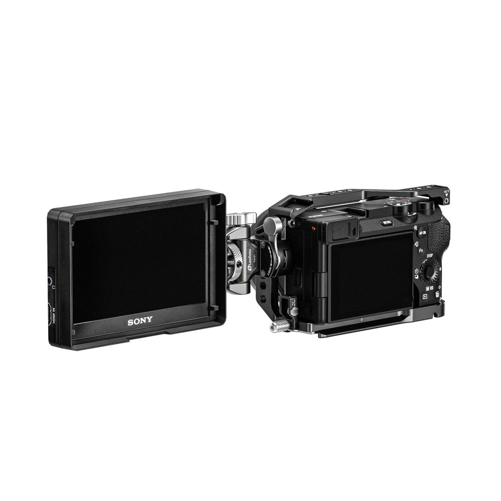 Black cinema camera rig with external monitor mounted on left side and rail clamp system, shown from side angle against white background.