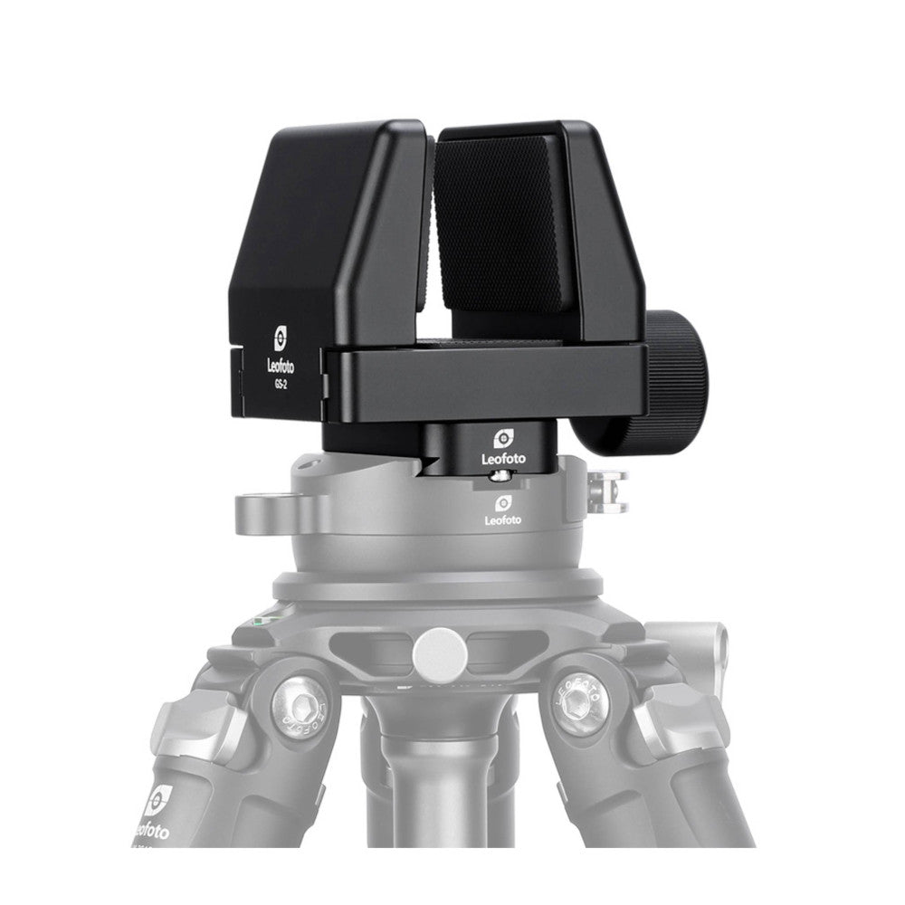 Black shooting rest clamp mounted on silver tripod head, shown from front angle with padded arms open and adjustment knob visible on right side.