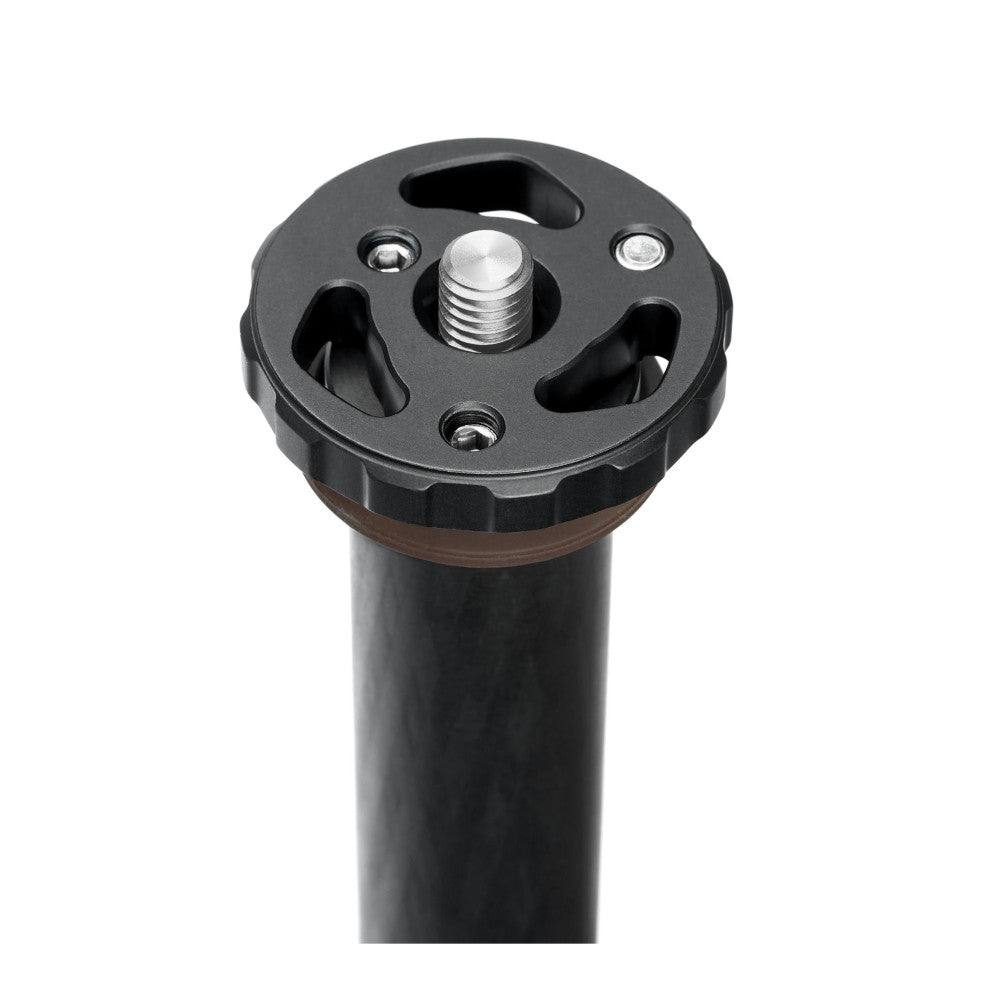 Close-up top view of black horizontal column with round panning base, showing metal center screw and mounting slots against white background.
