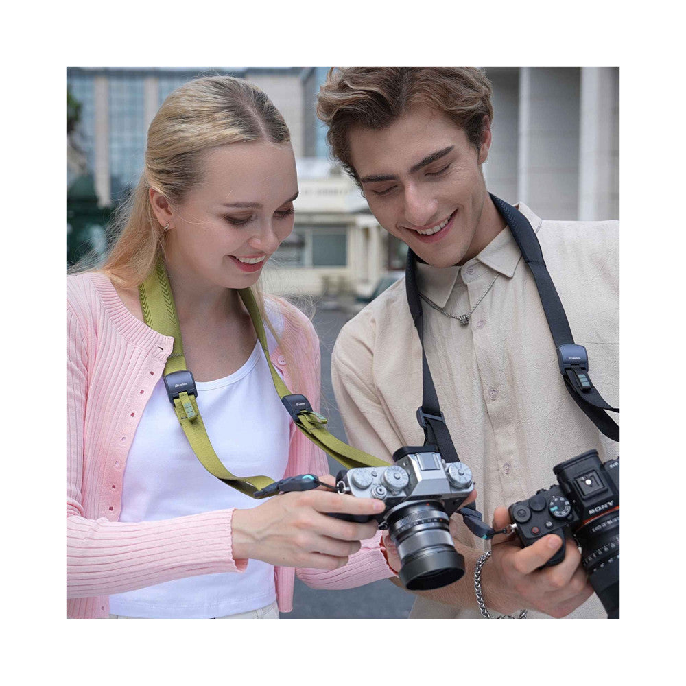Two people outdoors holding vintage cameras with yellow-green camera straps, demonstrating in-use product styling.