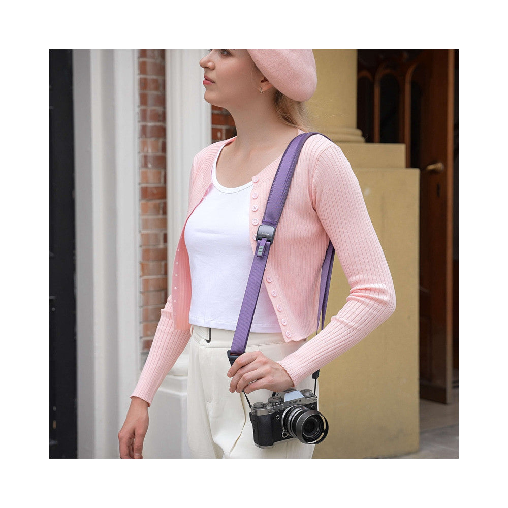 Woman wearing purple camera strap with vintage film camera, side profile view showing product in use.