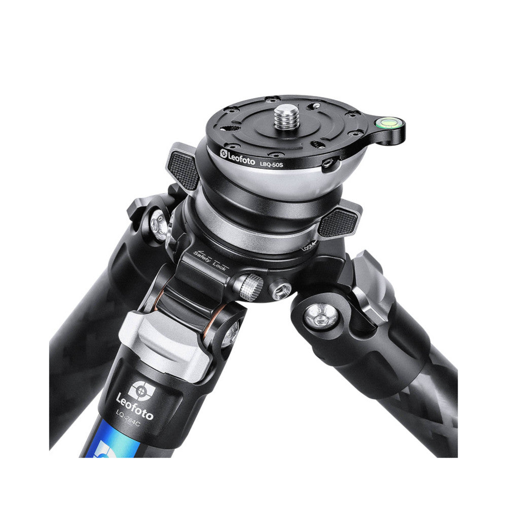 Leofoto LBQ-50S leveling base mounted on tripod legs, showing the ball head with level indicator and adjustment mechanisms from a close-up overhead angle.