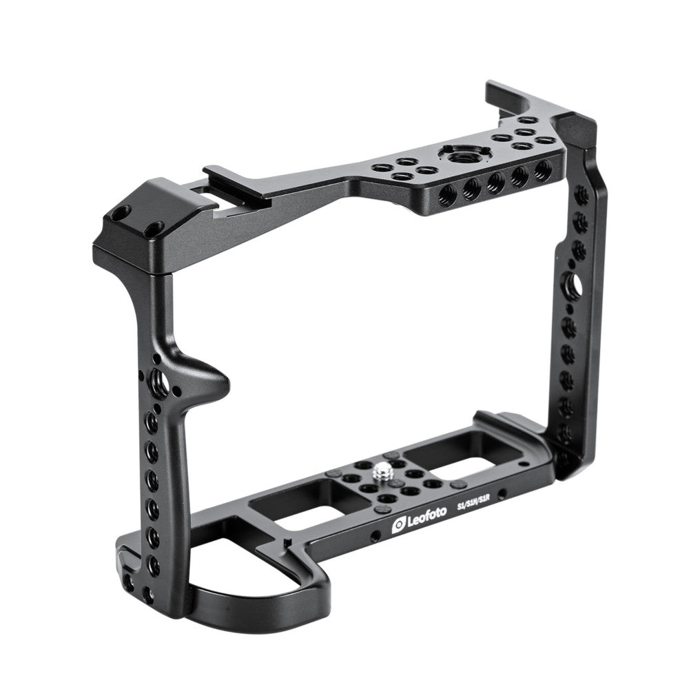 Black aluminum camera cage with mounting points and top handle, shown in three-quarter view against white background.