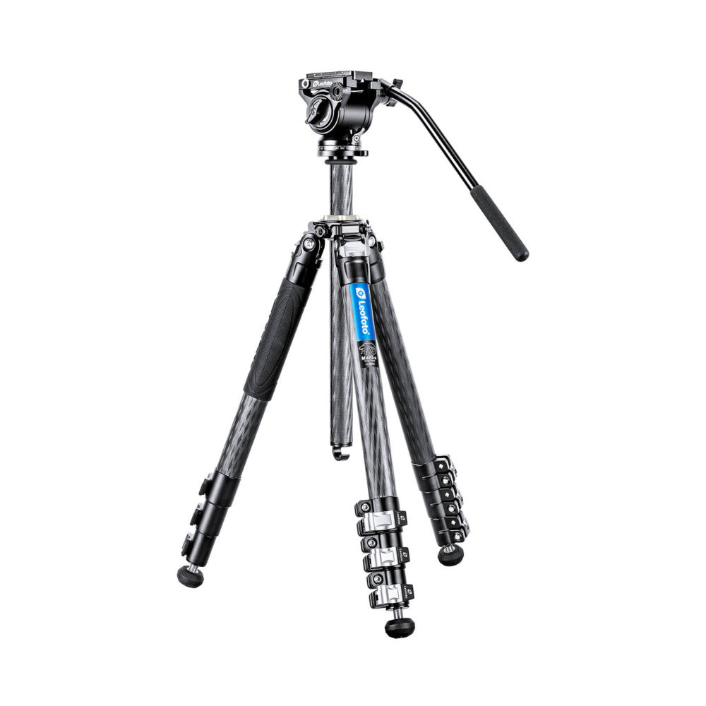 Professional carbon fiber video tripod with fluid head, shown from front angle against white background, displaying three extended legs and mounted video head with handle.