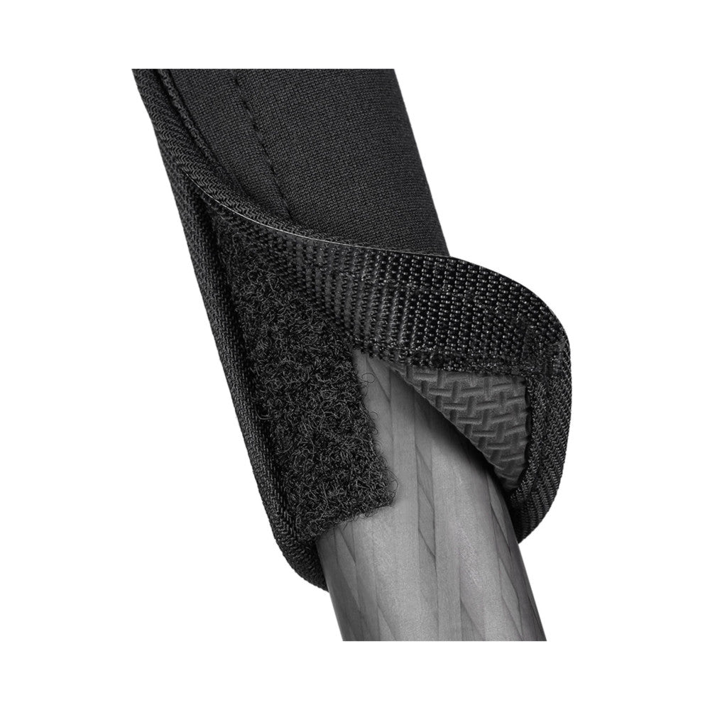 Close-up detail view of black neoprene leg wrap with hook-and-loop fastener applied to tripod leg, showing texture and fastening mechanism against white background.