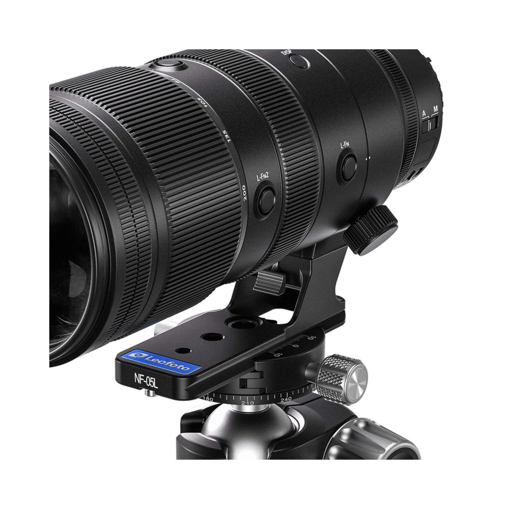 Black telephoto lens mounted on Leofoto NF-05L Arca lens foot with ball head, shown from side angle against white background.