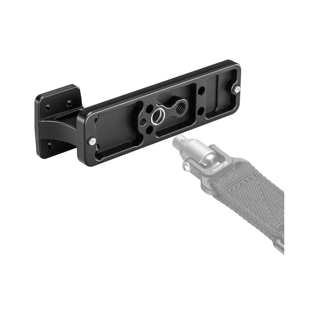Black metal lens foot bracket shown with attachment connector and strap, displayed at an angle with mounting hardware visible.