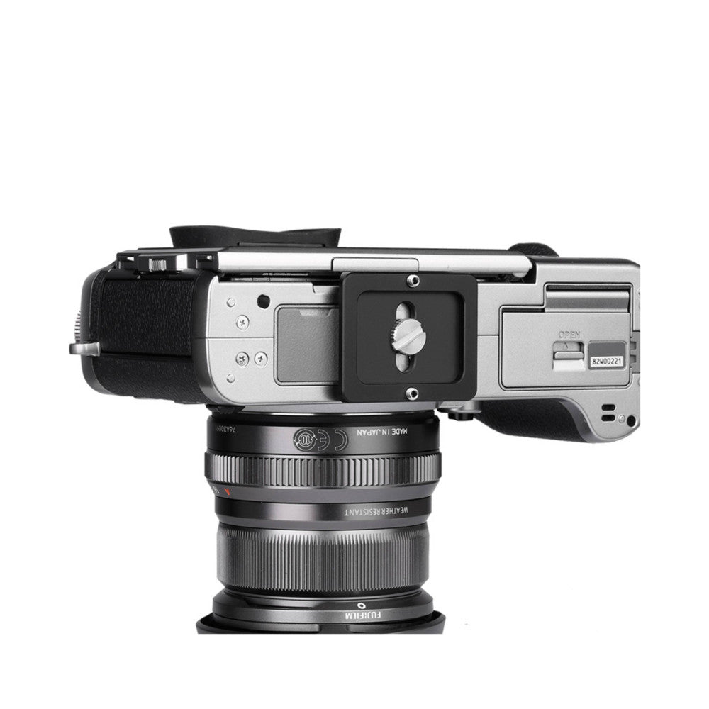 Top-down view of Leofoto NP-30 quick release plate mounted on camera with lens attached, showing the plate's clamp mechanism and positioning.