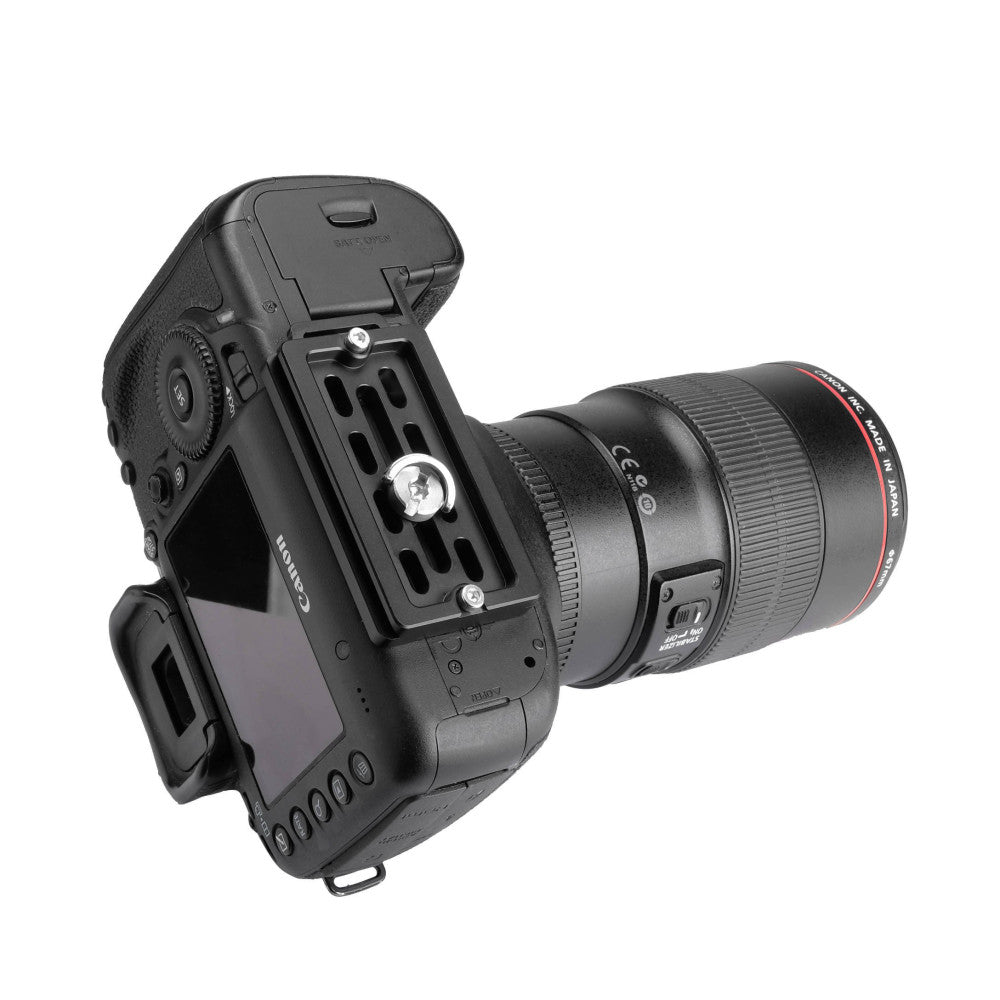 Black camera mounting plate attached to DSLR camera with telephoto lens, shown from overhead angled view displaying the quick-release plate and mounting interface.