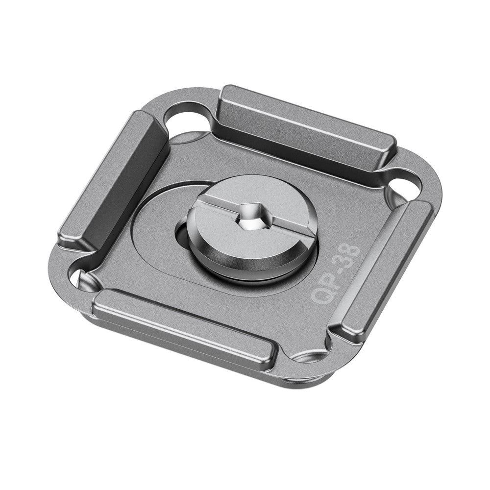Isometric view of a silver metal quick release plate with circular knob and mounting holes, showing top and side angles.