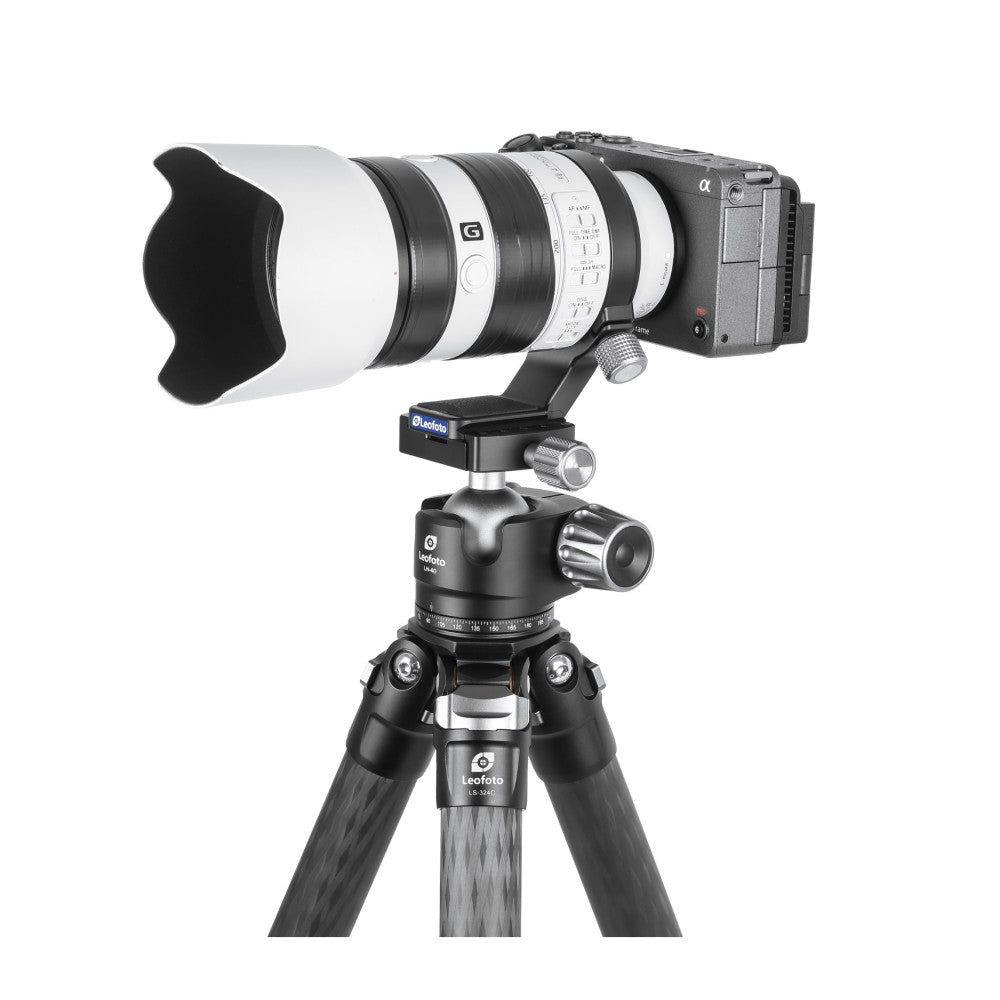 Sony camera with telephoto lens mounted on Leofoto tripod head and legs, shown from side angle with lens collar visible.