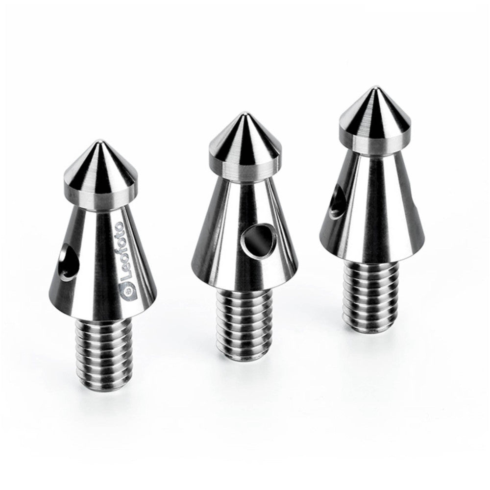 Three polished titanium tripod spikes with conical pointed tops and threaded bases, displayed at an isometric angle against a white background.