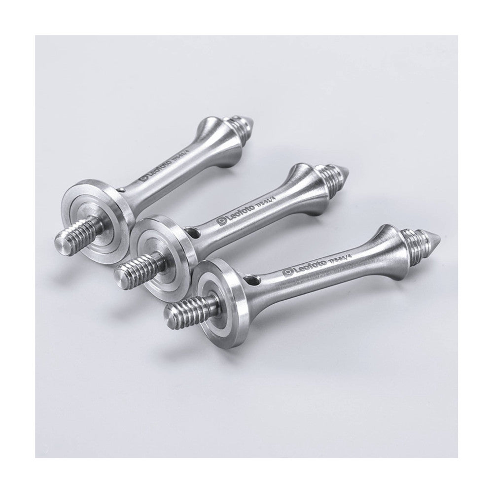 Three silver tripod spikes with threaded bases and conical points, arranged at angles against a light gray background, product detail view.