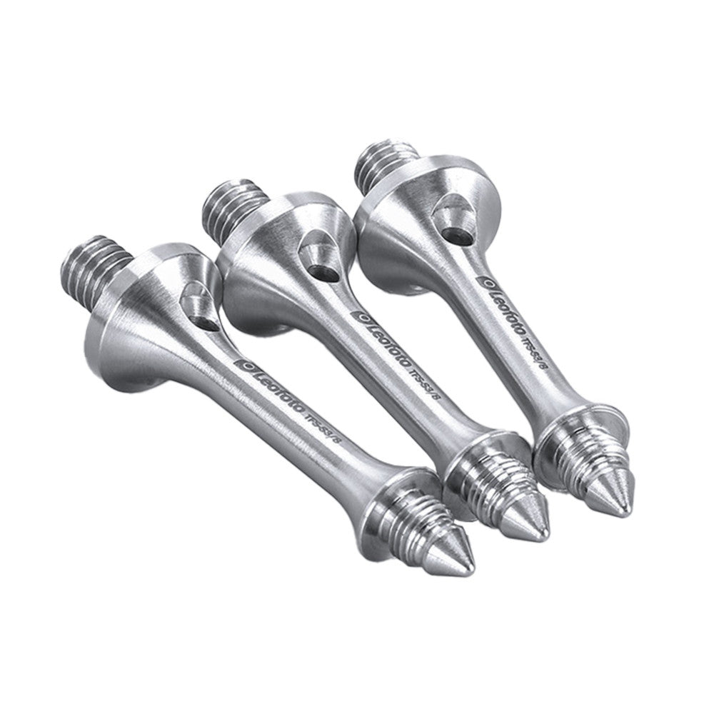 Three silver tripod spikes with threaded bases arranged in a row against a white background, angled view showing pointed tips and cylindrical bodies.