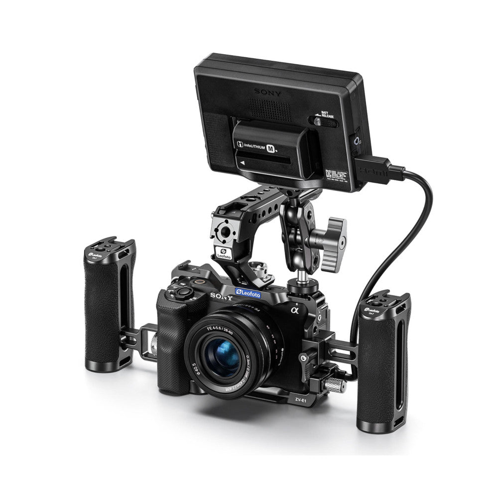 Sony ZV-E1 camera with Leofoto cage rig, mounted monitor, side handles, and external battery shown from front three-quarter view.