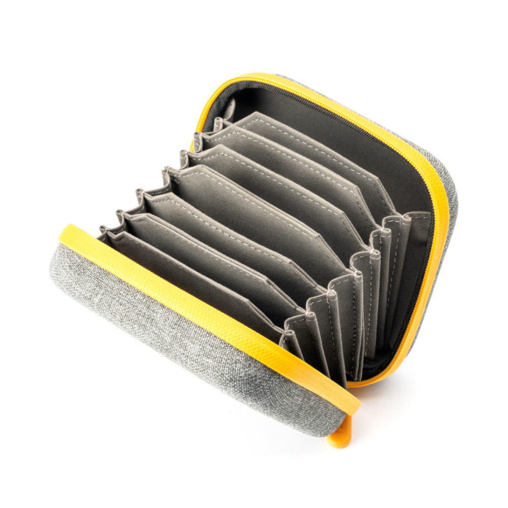 Open yellow and gray filter storage case displaying multiple stacked gray lens filters inside with black compartments.