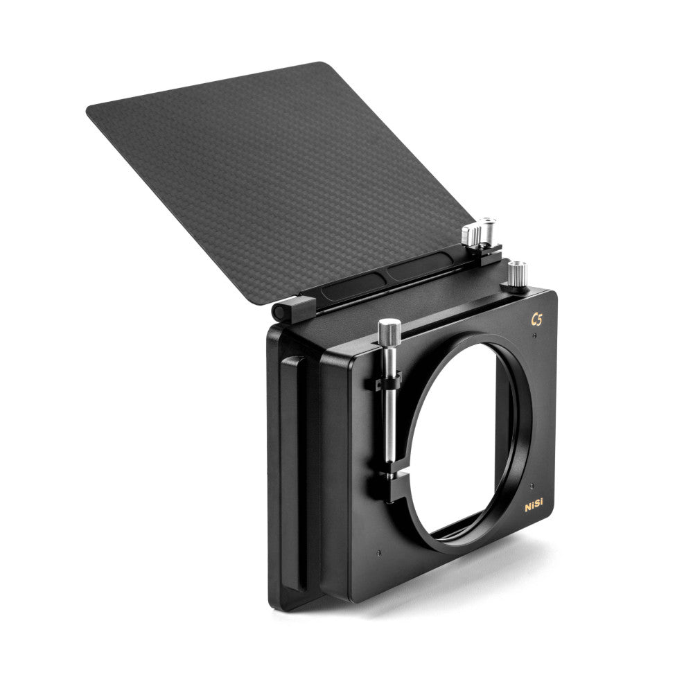 Black matte box with circular lens mount and tilted top filter tray, shown from isometric angle against white background.