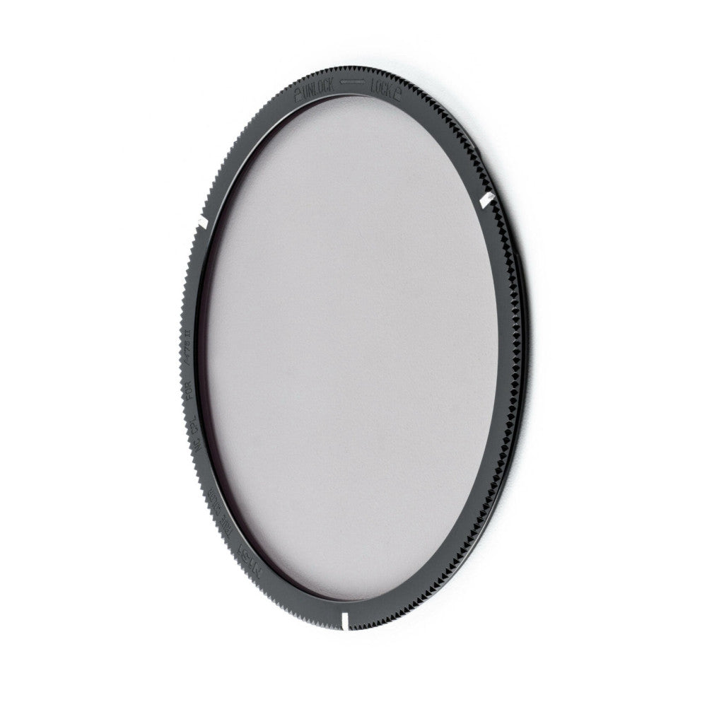 Circular polarizing filter with dark textured rim and gear-tooth edge, shown at slight angle against white background.