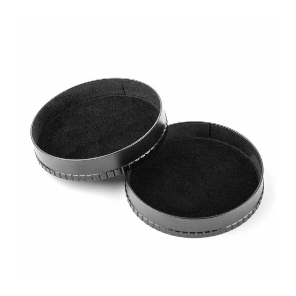 Two black lens caps with textured grip rings shown at an angle against a white background.