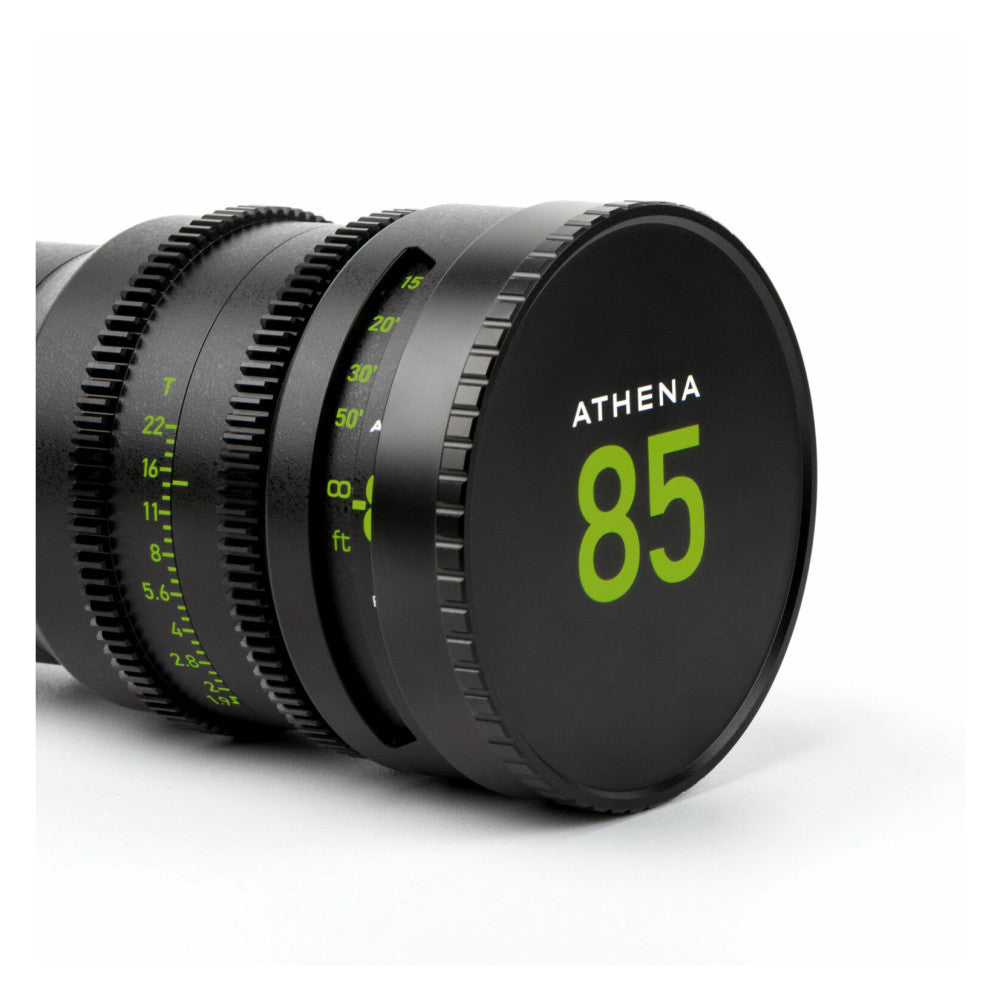 Close-up side view of NiSi ATHENA 85mm cinema lens showing focus ring markings and rear lens cap with green branding.
