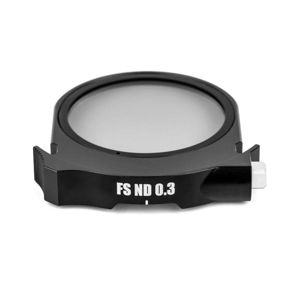 Black circular ND filter with "FS ND 0.3" label visible, shown at an angle against white background displaying the filter's glass lens and mounting frame.