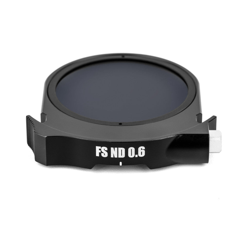 Top-down view of a circular black ND filter with "FS ND 0.6" label, showing the dark tinted glass element and mounting brackets.
