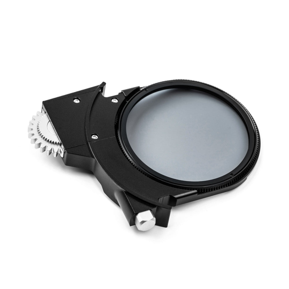 Black polarizer filter attachment with white gear mechanism shown at an angle against white background, displaying the circular glass filter element and mounting hardware.