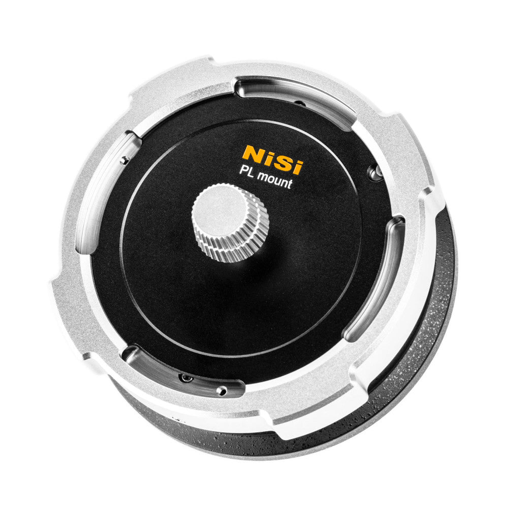 Top-down view of NiSi PL mount adapter showing silver outer ring, black center disc with yellow NiSi branding, and central gear mechanism for lens mounting.