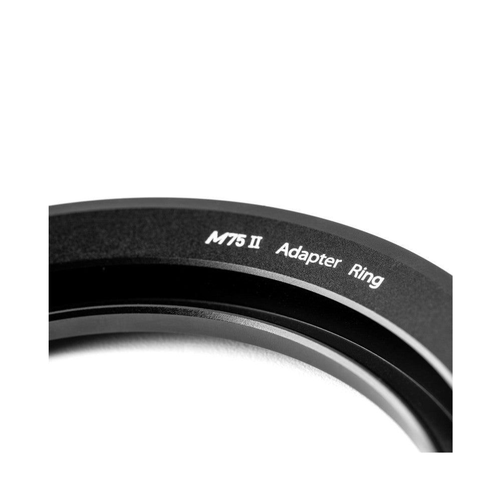 Close-up of M75 II adapter ring showing engraved text on black metal surface against white background