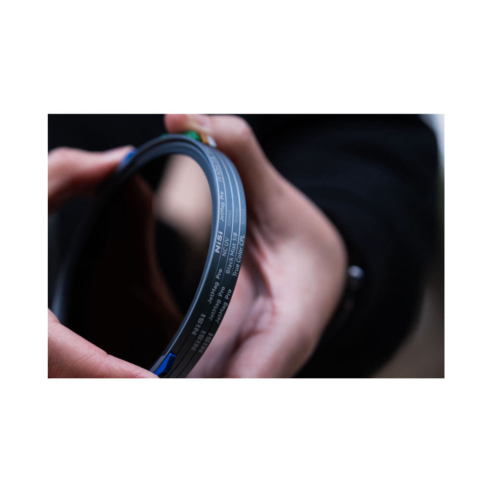 Close-up of NiSi JetMag Pro magnetic filter held in hand, showing printed specifications and branding on the dark filter ring.