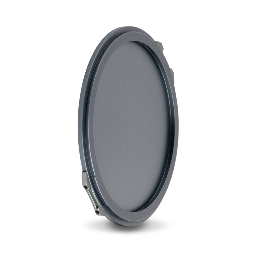 Gray circular magnetic lens cap shown at an angle, displaying the front surface and metal attachment mechanism on the side.