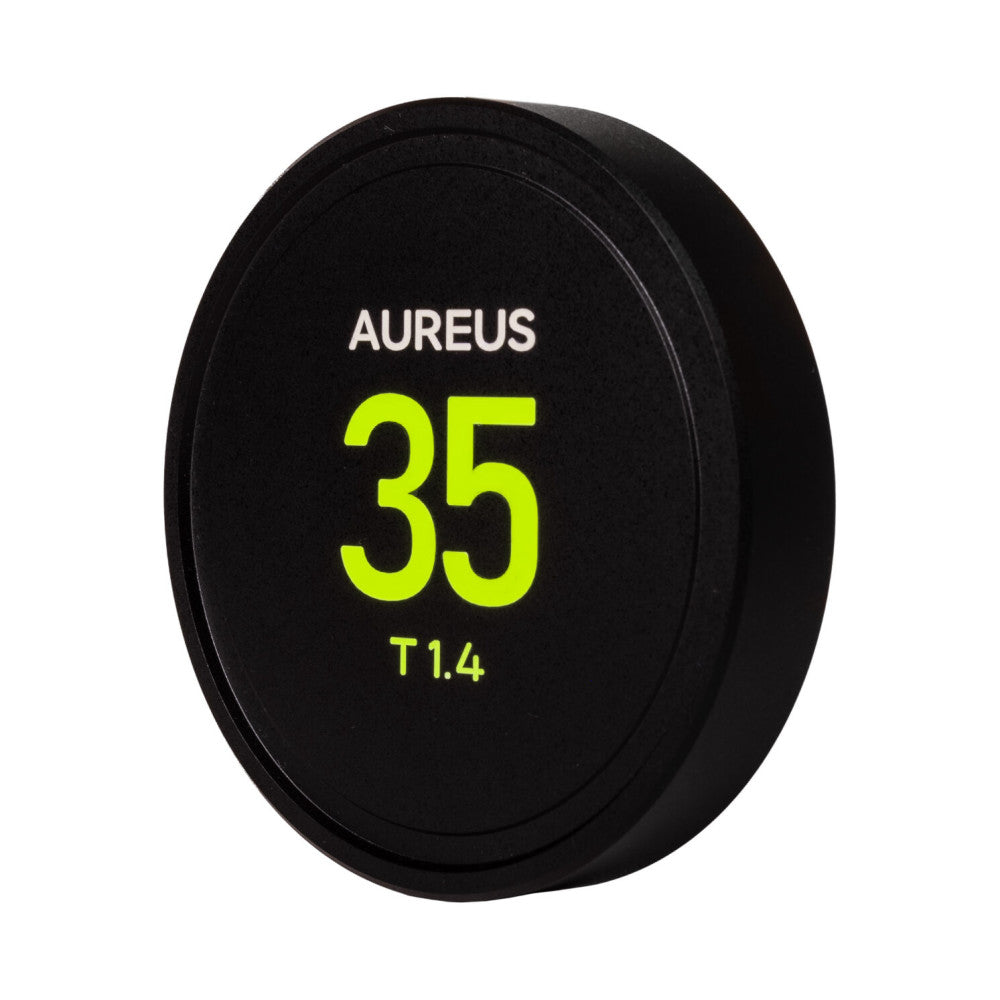 Black circular lens cap with white "AUREUS" text and neon yellow "35" and "T1.4" specifications displayed on front surface, angled view.