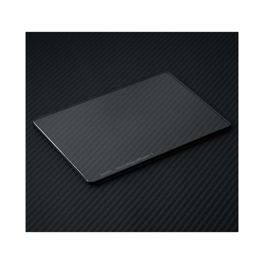 Angled view of a rectangular glass filter with beveled edges on a dark carbon fiber textured background, showing the product name embossed on the lower edge.
