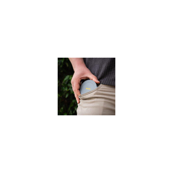 Person holding NiSi JetMag Pro magnetic front cap in hand, showing the cap's curved design and gray finish against neutral clothing.