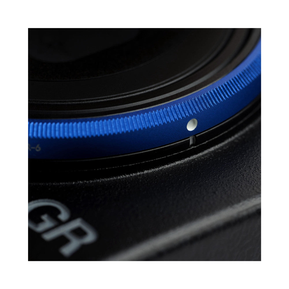 Close-up detail of blue and gray lens cap rings showing textured surfaces and metal attachment point against black background.
