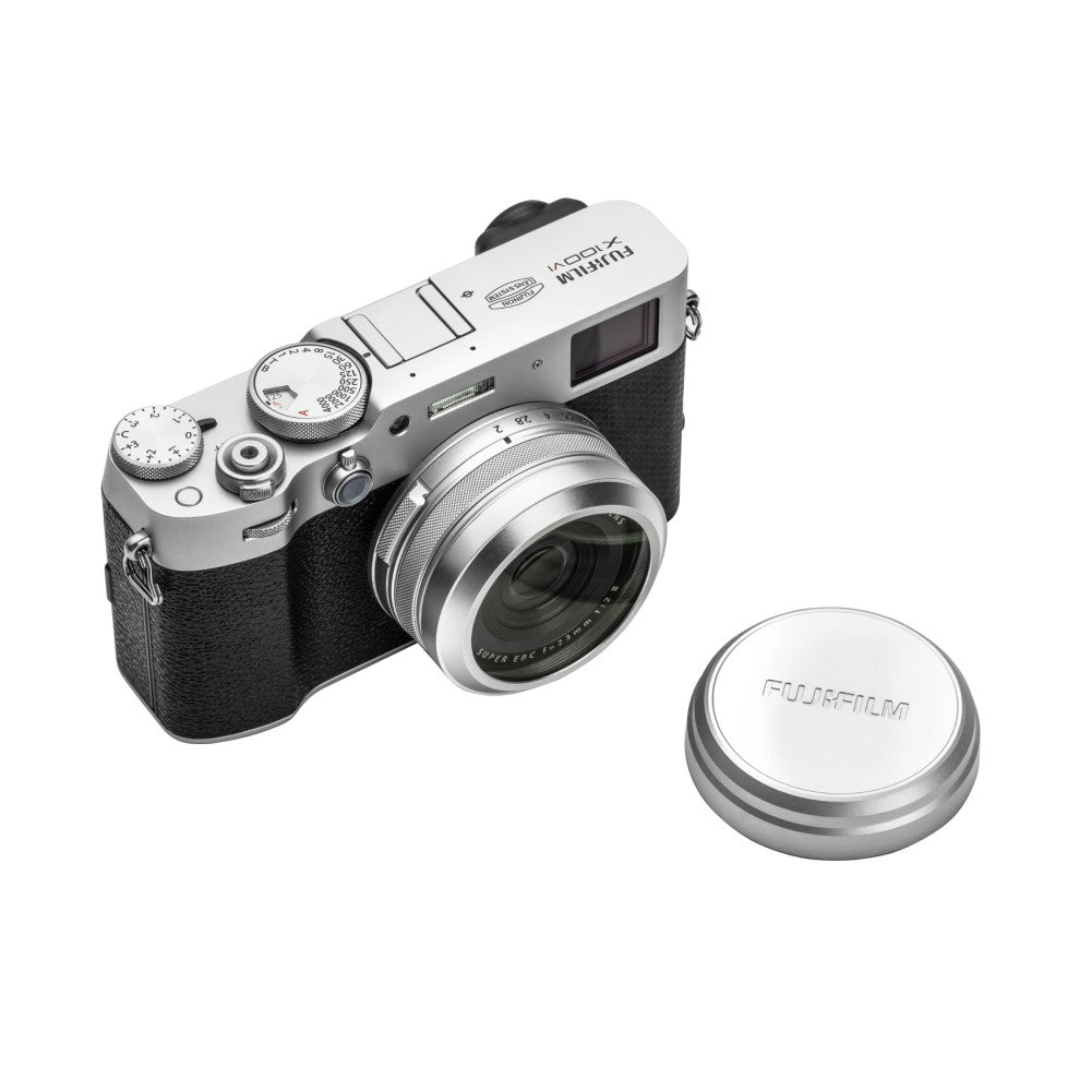 Fujifilm X100 camera with silver lens cap displayed at three-quarter angle against white background.