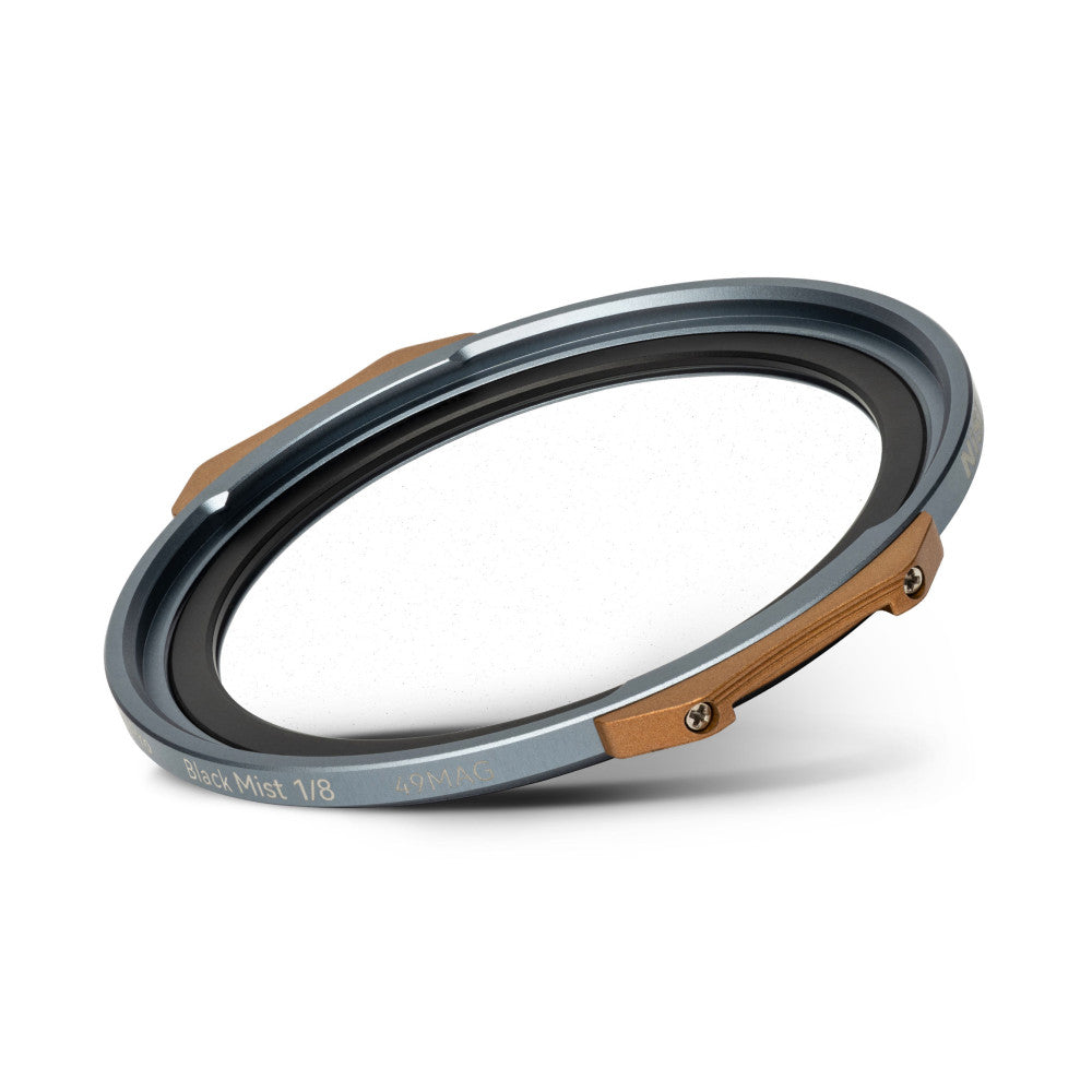 Angled view of a circular magnetic filter with gray metal ring, black inner surface, and tan leather attachment straps on opposite sides.