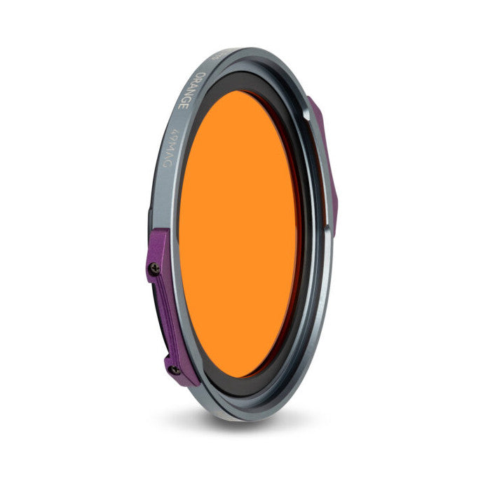 Angled view of a round magnetic filter with orange glass center, gray outer ring, and purple magnetic attachment points visible on the side.