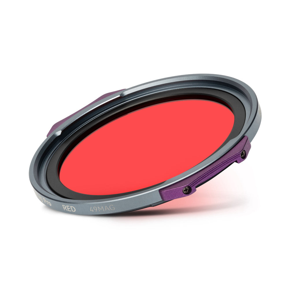 Angled view of a red magnetic filter with gray and purple components, showing the circular red glass and mounting ring against a white background.