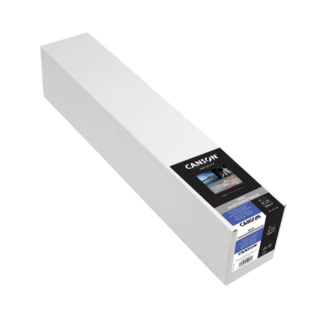 Long white roll of photography paper with black product label and blue band visible on the end, photographed at an angle against white background.